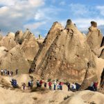 Visitors walking among the fairy chimneys of Cappadocia