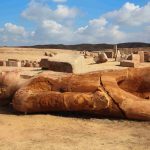 Fallen colossal statue among ancient ruins in Egypt