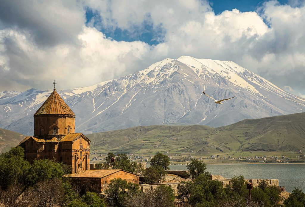 Akdamar Church on Lake Van with snow-capped mountains