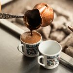 Turkish coffee poured from a copper pot